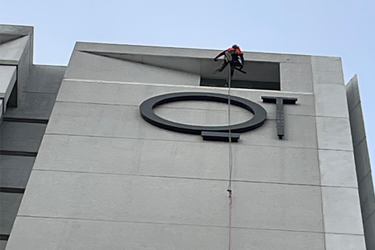 A high-rise hotel building overlooking an outdoor swimming pool area.