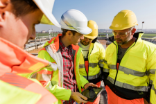 A modern glass building reflecting the sky and clouds, highlighting the need for high-rise window cleaning.