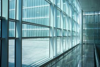 A rope access technician cleans the windows of a high-rise building.
