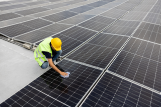 A rope access technician cleans the windows of a high-rise building.