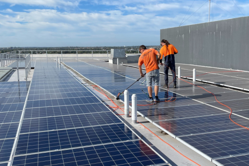 A rope access technician cleans the windows of a high-rise building.