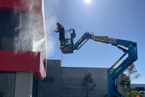 A rope access technician cleans the windows of a high-rise building.