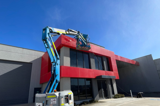 A modern glass building reflecting the sky and clouds, highlighting the need for high-rise window cleaning.