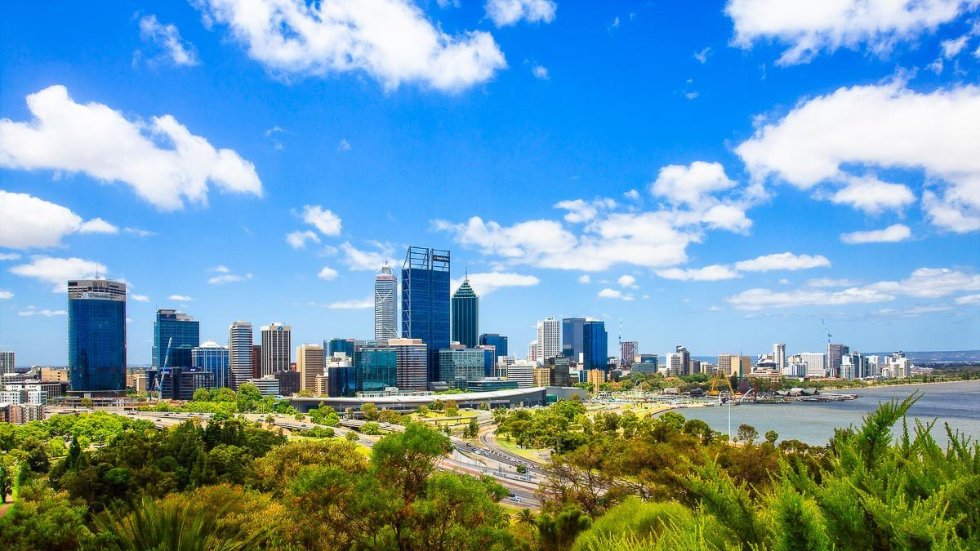 A cluster of high-rise buildings with reflective glass facades and numerous windows, towering over the city skyline on a clear day.